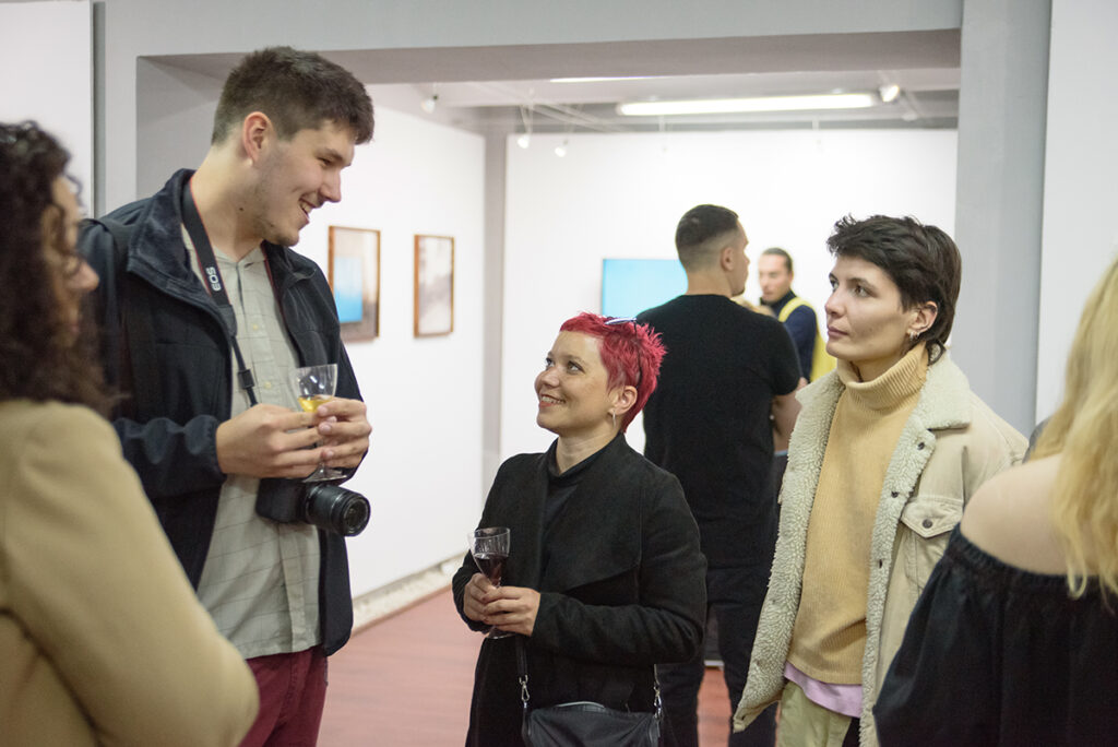 Un instantaneu de atmosferă de la expoziția Q (curios, criptic, cataleptic) organizat de către Galeria Vault One & Korunk din Cluj-Napoca, în parteneriat cu revista Nophto organizează expoziția intitulată Q (curios, criptic, cataleptic) . În imagine este Vlad Filip, dezvoltator web, Oana Muscan artist fotograf si alți invitați ai evenimentului.