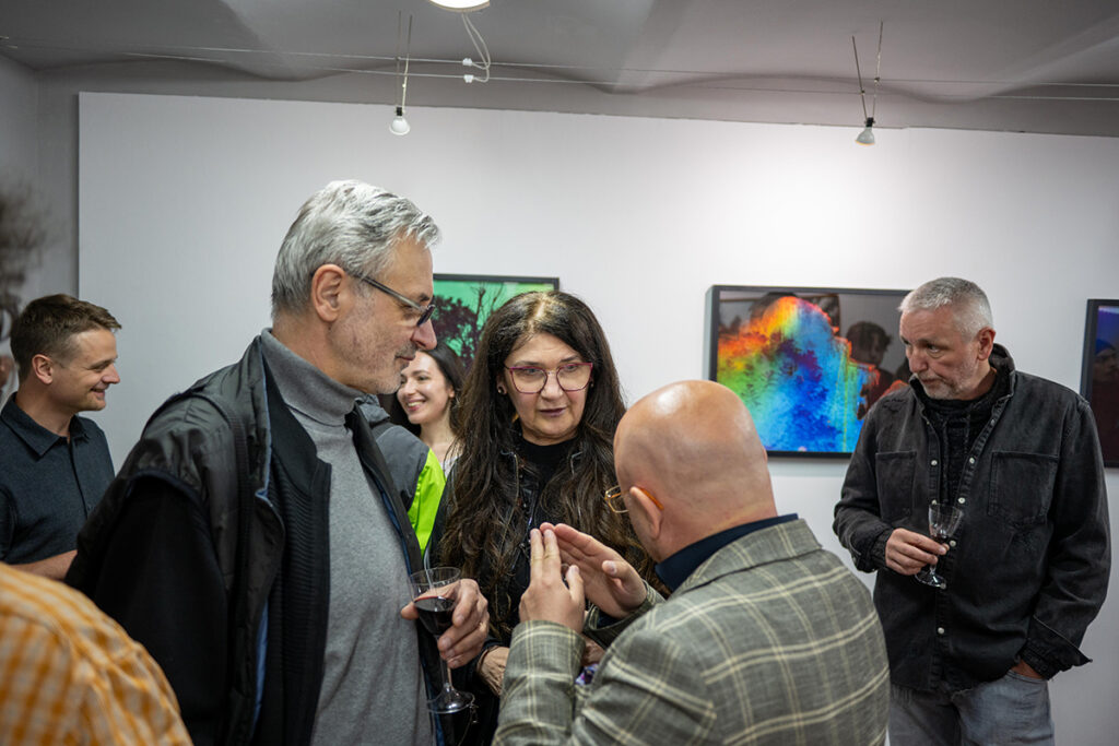 În imagine este artista Hermina Csata, alături de pictorul Radu șerban. Un instantaneu de atmosferă de la vernisajul expoziției Q (curios, criptic, cataleptic) organizat de către Galeria Vault One & Korunk din Cluj-Napoca, în partneriat cu revista de fotografie Nophto cu lucrări ale artiștilor Mira Marincaș și Havadi-Nagy-David István, curator Teff Hășmășan.